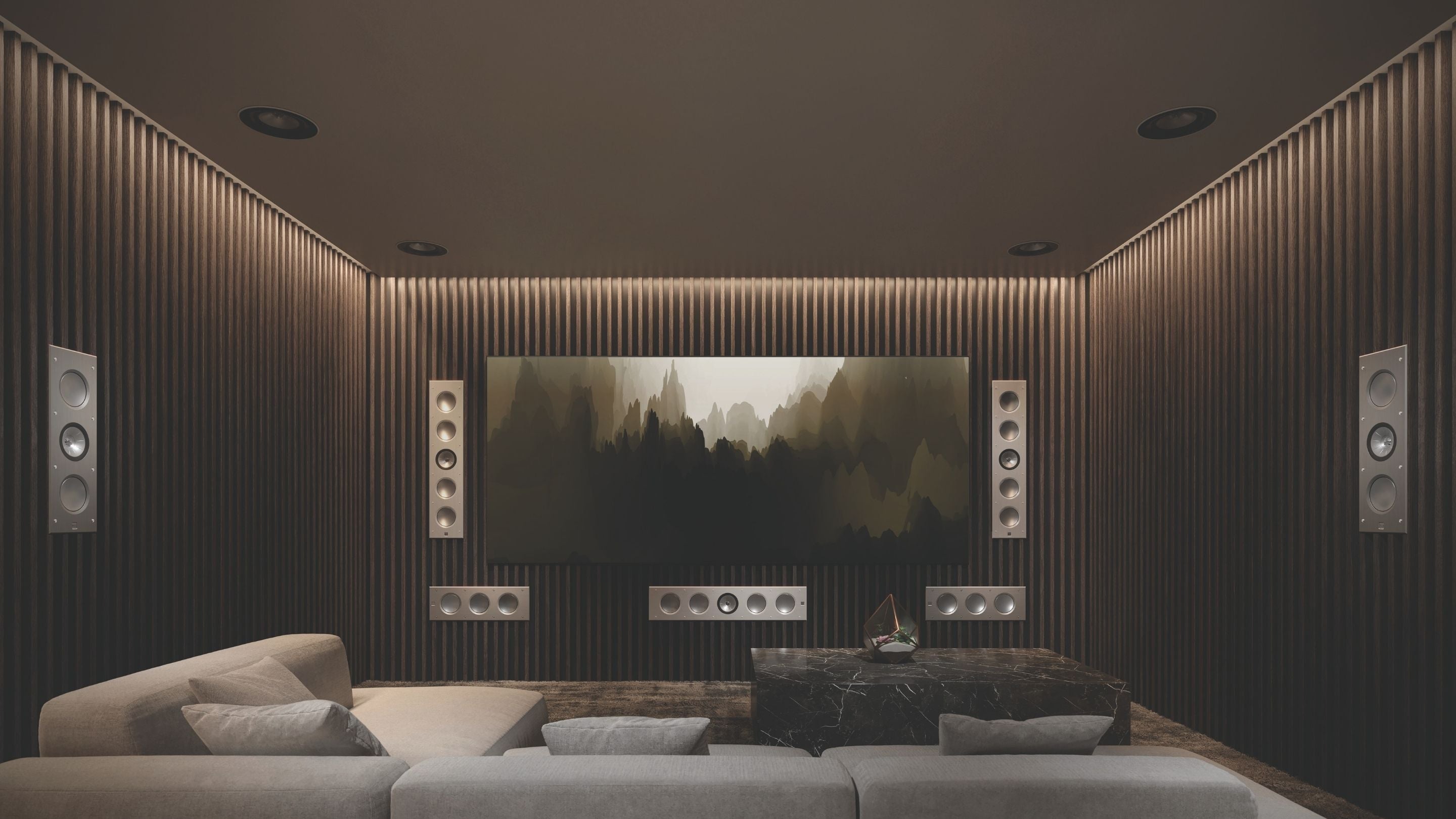 A sleek home theater setup with a large screen, displaying KEF architectural speakers  Ci5160RLM-THX speakers and smaller Ci3160RLM-THX speakers.