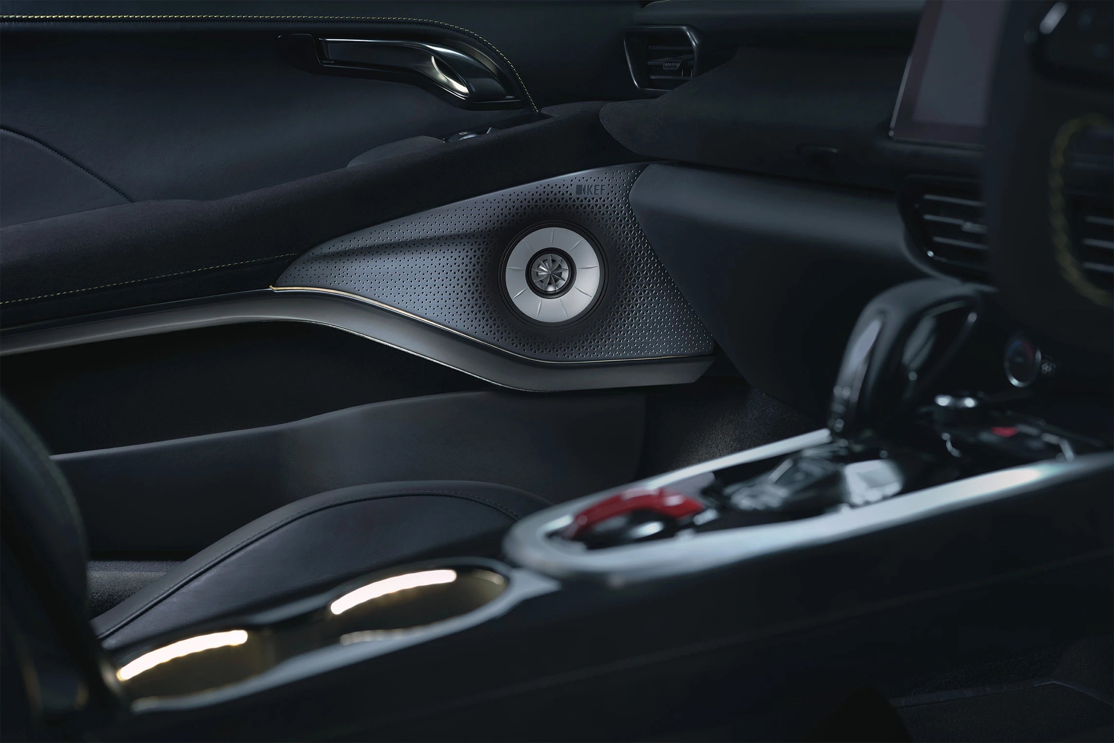 Close-up of a Lotus Emira car interior door panel with a KEF speaker and part of the center console.